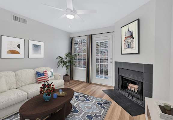 A living room with a fireplace, a couch, a coffee table, and pictures on the wall.