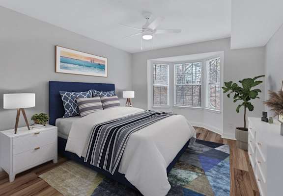 A bedroom with a bed, nightstand, and a painting on the wall.