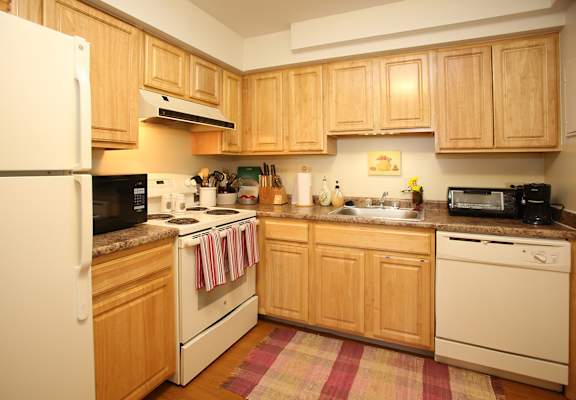 a kitchen with white appliances and wooden cabinets