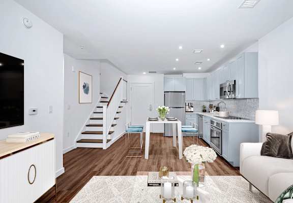 A modern living room with a staircase leading to the upper floor at Seminary Towers, Alexandria
