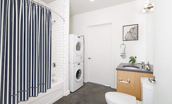 Bathroom with a washing machine and a toilet