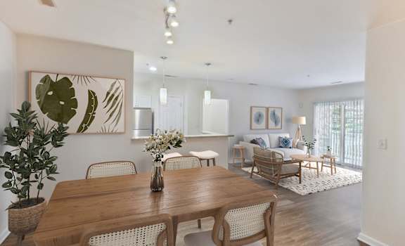 a living room and dining room with a wooden table and chairs at Highlands at Faxon Woods, Quincy, MA