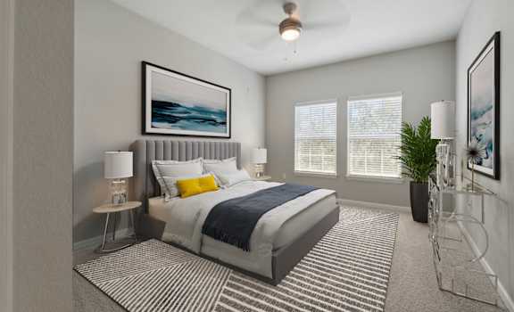 a bedroom with a large bed and two windows at Village at Terra Bella Apartments, Land O' Lakes, Florida