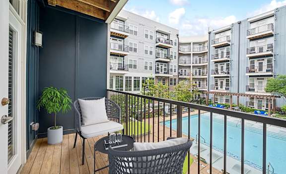 a balcony with chairs and a pool and an apartment building at Glenwood at Grant Park, Georgia, 30316