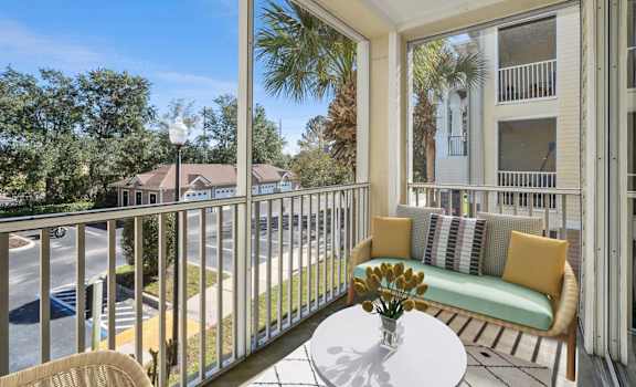 a patio with a couch and a table on a balcony at Grandeville on Saxon, Orange City, Florida