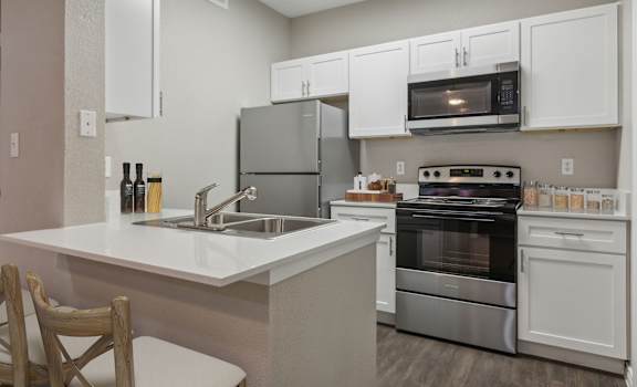 a kitchen with white cabinets and stainless steel appliances and a sink