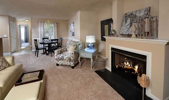 A living room with a fireplace and a chair with a floral pattern.