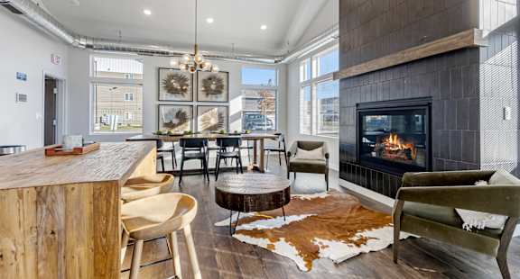 A modern living room with a fireplace and a cowhide rug.