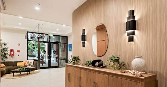 A wooden cabinet with a mirror and lights above it.