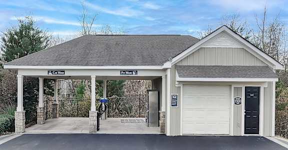 the front of a garage with a driveway and a white door