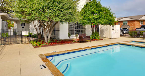 a swimming pool with trees and a house in the background