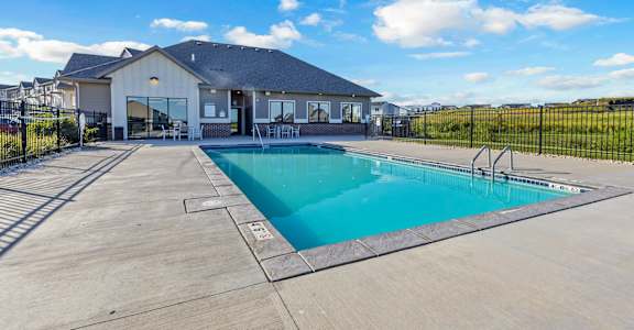 A swimming pool in front of a house.