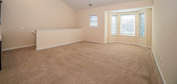 a bedroom with carpeting and a large window