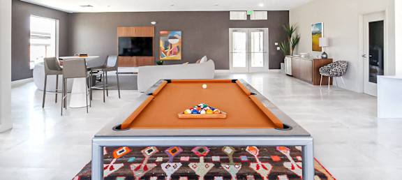a large living room with a pool table in the middle of it