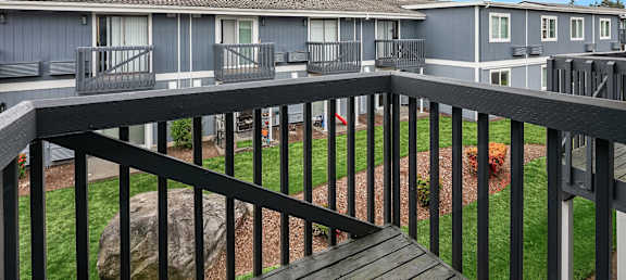 A balcony overlooks a baseball field and apartment buildings.