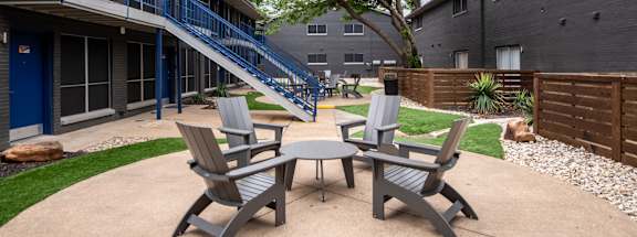 Stadium 700 patio with four chairs and a table outside of a building