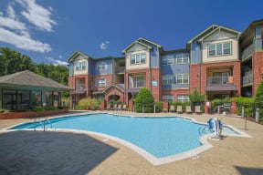 an outdoor swimming pool with an apartment building in the background