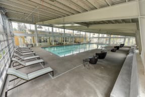 Indoor Swimming Pool Lounge Area with Lounge Chairs and Black Chairs
