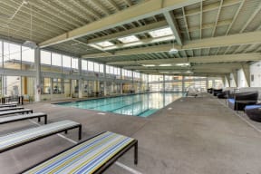 Indoor Swimming Pool Lounge Area with Lounge Chairs and Black Chairs