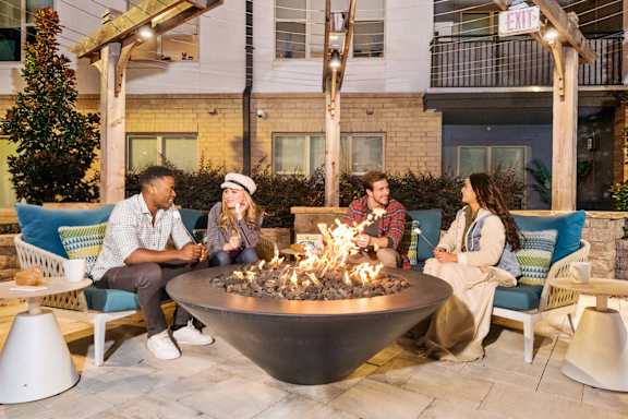 A patio with a yellow canopy and a fire pit.