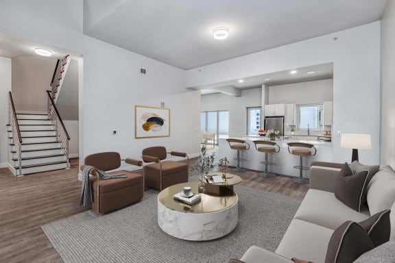 a living room with couches and chairs and a kitchen with a staircase at Paramount on Lake Eola Apartments, Orlando, Florida