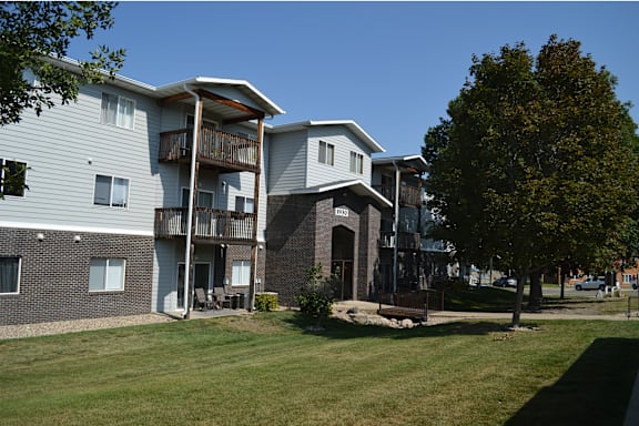 A sign for Calgary Apartments is in front of a building.