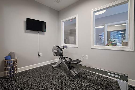 an office with a chair and a television in the corner