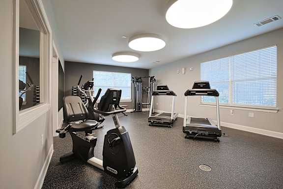 a gym with exercise machines and a large window