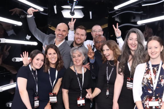 a group of people posing for a picture with their hands in the air