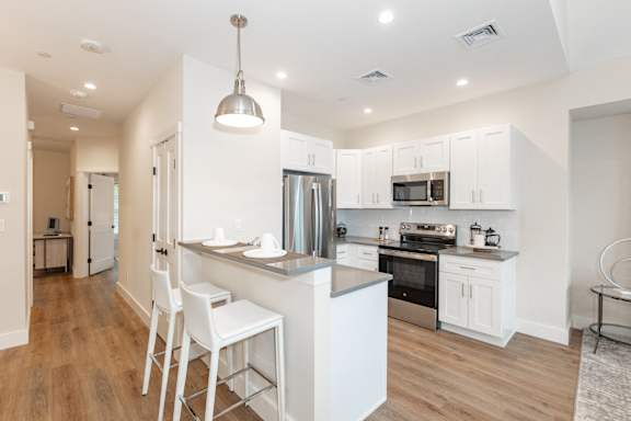 an empty kitchen with stainless steel appliances and black cabinets