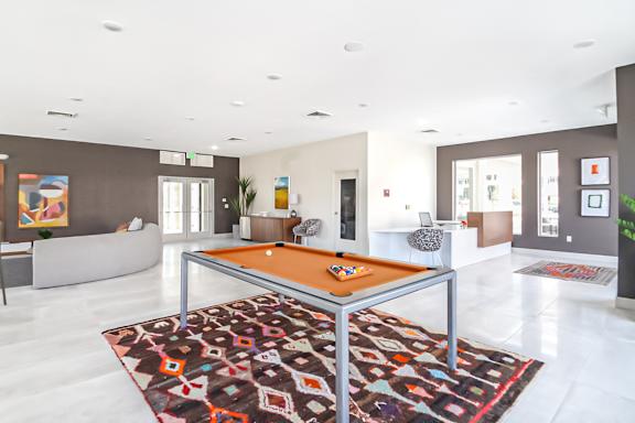 A billiard table in the middle of a room with a rug.