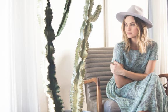 a woman sitting on a chair next to a cactus