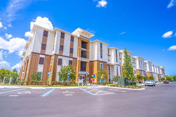 A modern building with a parking lot in front of it.