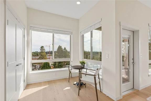 A dining room with a table and chairs and a view of the outdoors.