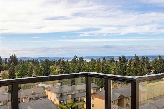 A balcony overlooks a residential area with houses and trees.