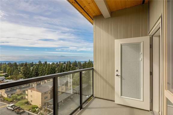 A balcony with a glass railing and a white door.