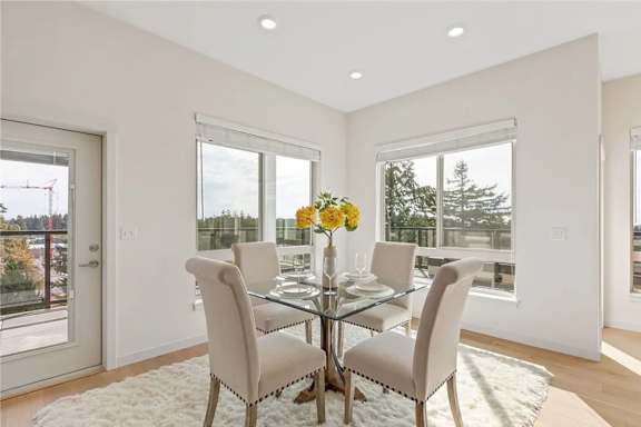 A dining room with a glass table and chairs.