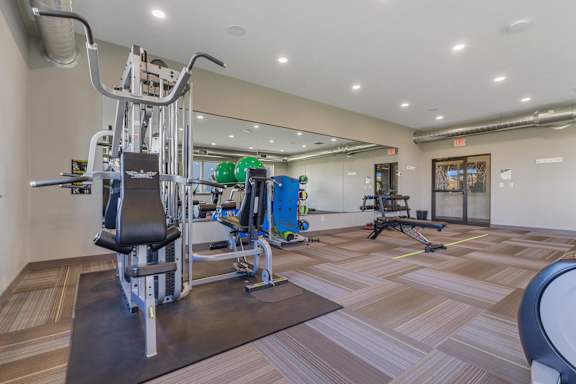 A gym with a variety of equipment including a leg press machine.