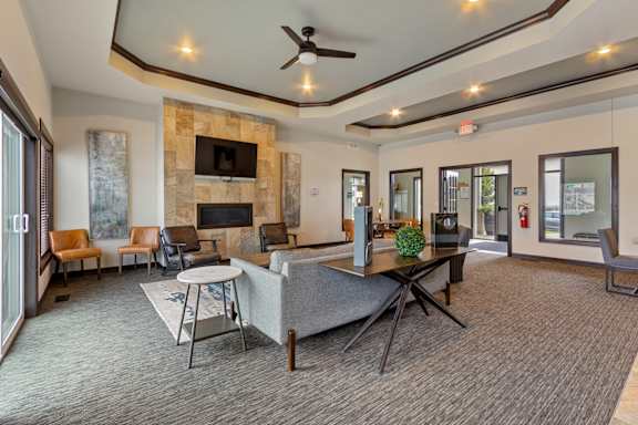 A living room with a grey couch and a stone fireplace.