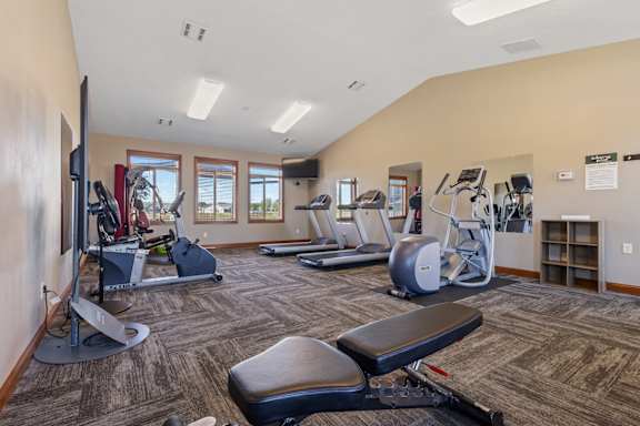 A gym with a variety of equipment including treadmills, weights, and exercise machines.