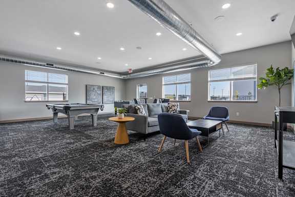 A room with a grey carpet and a table with a yellow top.