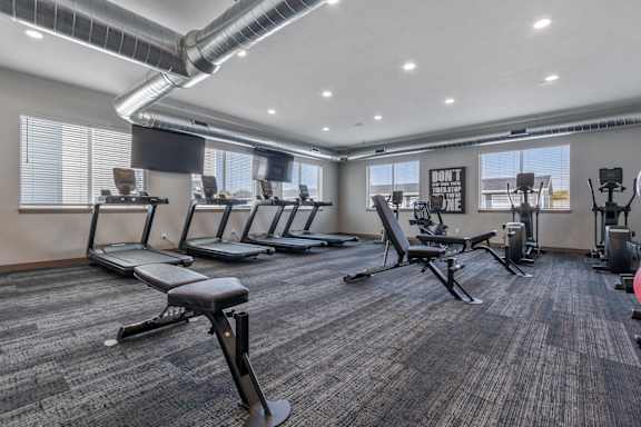 A gym with treadmills, exercise bikes, and other equipment.