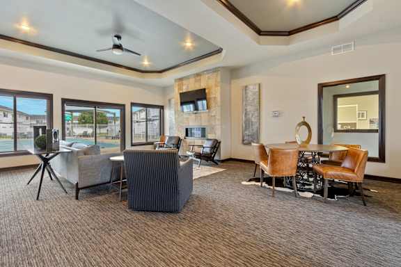 A spacious living room with a grey carpet and a variety of seating options.