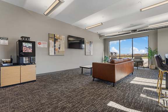 A conference room with a brown sofa and a wooden cabinet.