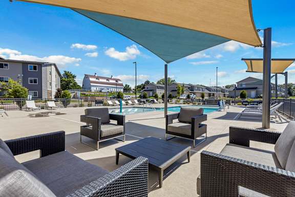 A sunny day at the poolside with lounge chairs and umbrellas.