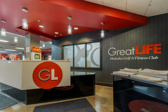 The image shows the front desk of the Great Life Maluska Golf & Fitness Club.