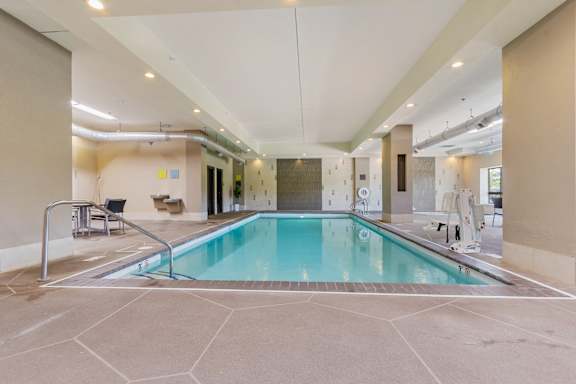 A large indoor swimming pool with a tiled floor.