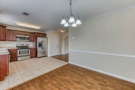 an empty living room with wood floors and a ceiling fan