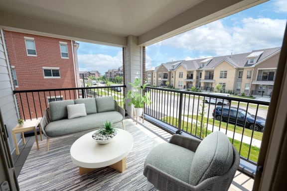 a living room with couches and a table on a balcony