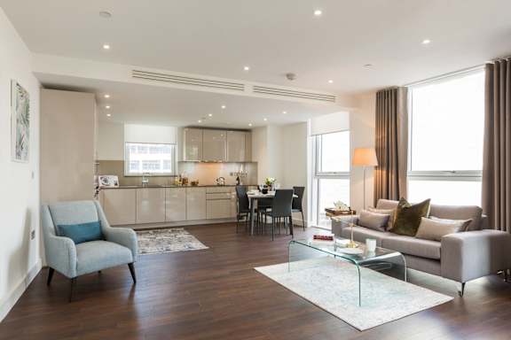 a living room with a couch and a table in front of a kitchen